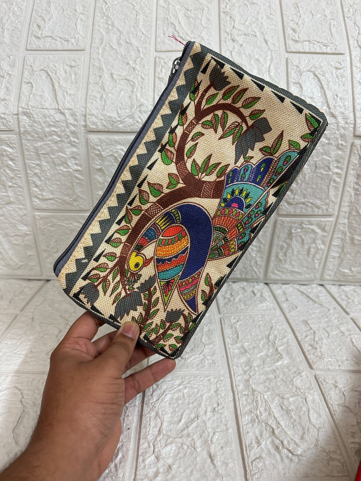Handheld clutch with colorful tree design on a tiled floor background