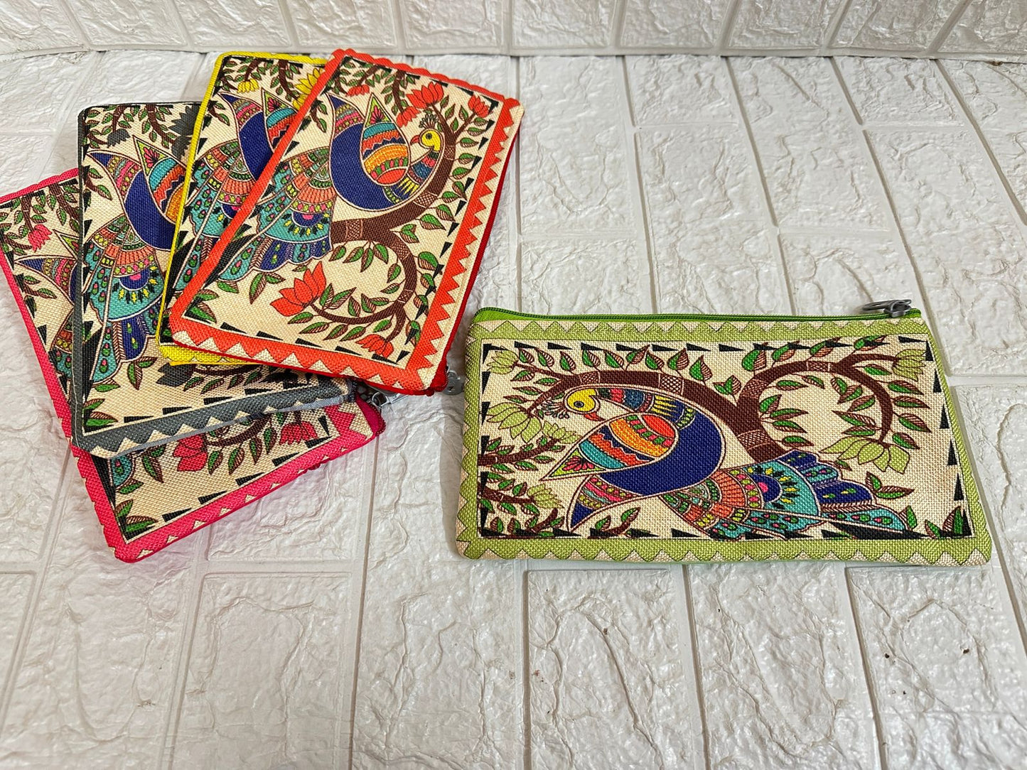 Colorful hand-painted pouches on a light gray tiled floor
