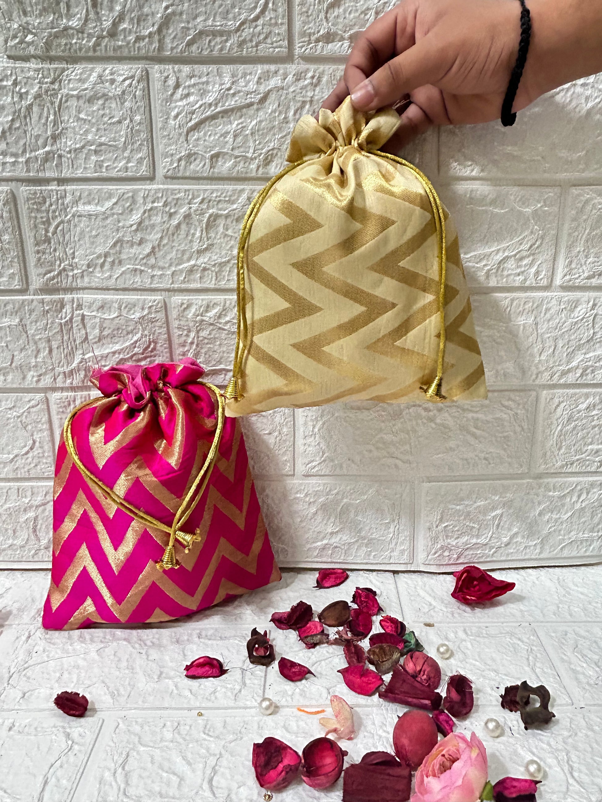 DesiTohfa Brocade Potli Bags in gold and pink with zigzag patterns and drawstring closure