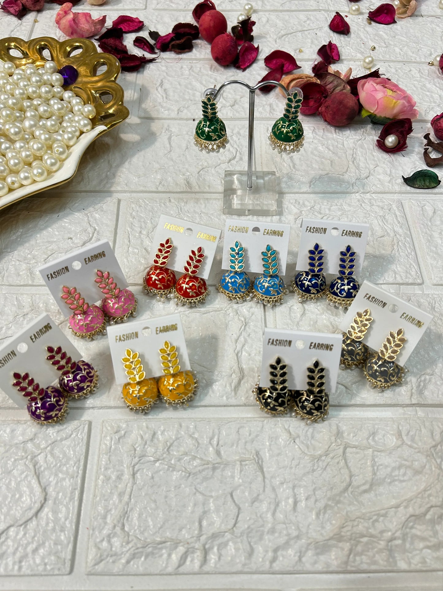 Colorful collection of DesiTohfa Jhumki Earrings with intricate designs displayed on white surface