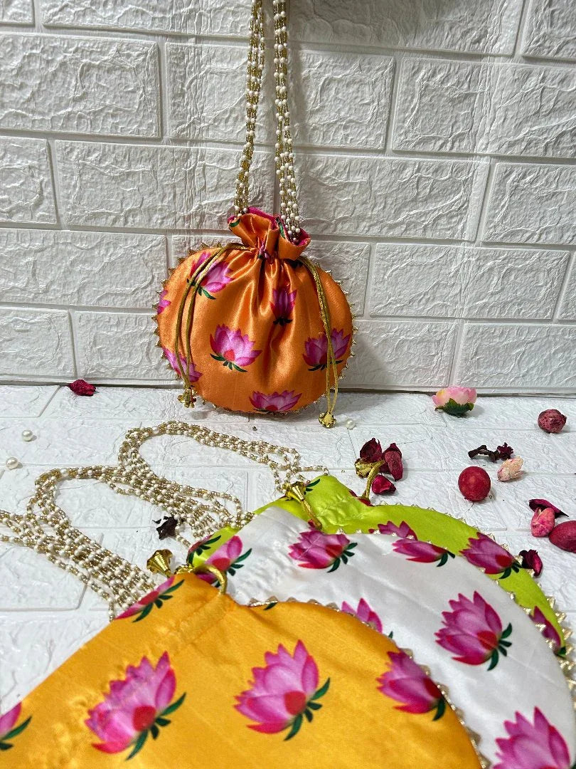 Colorful DesiTohfa Potli Bags in orange, yellow, green, and white with floral lotus patterns and pearl handles