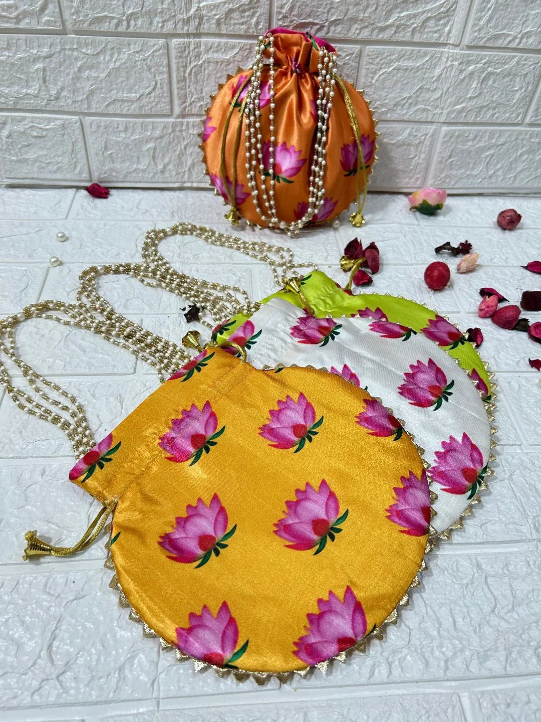DesiTohfa Potli Bags in orange satin with pink floral design and pearl chain handles