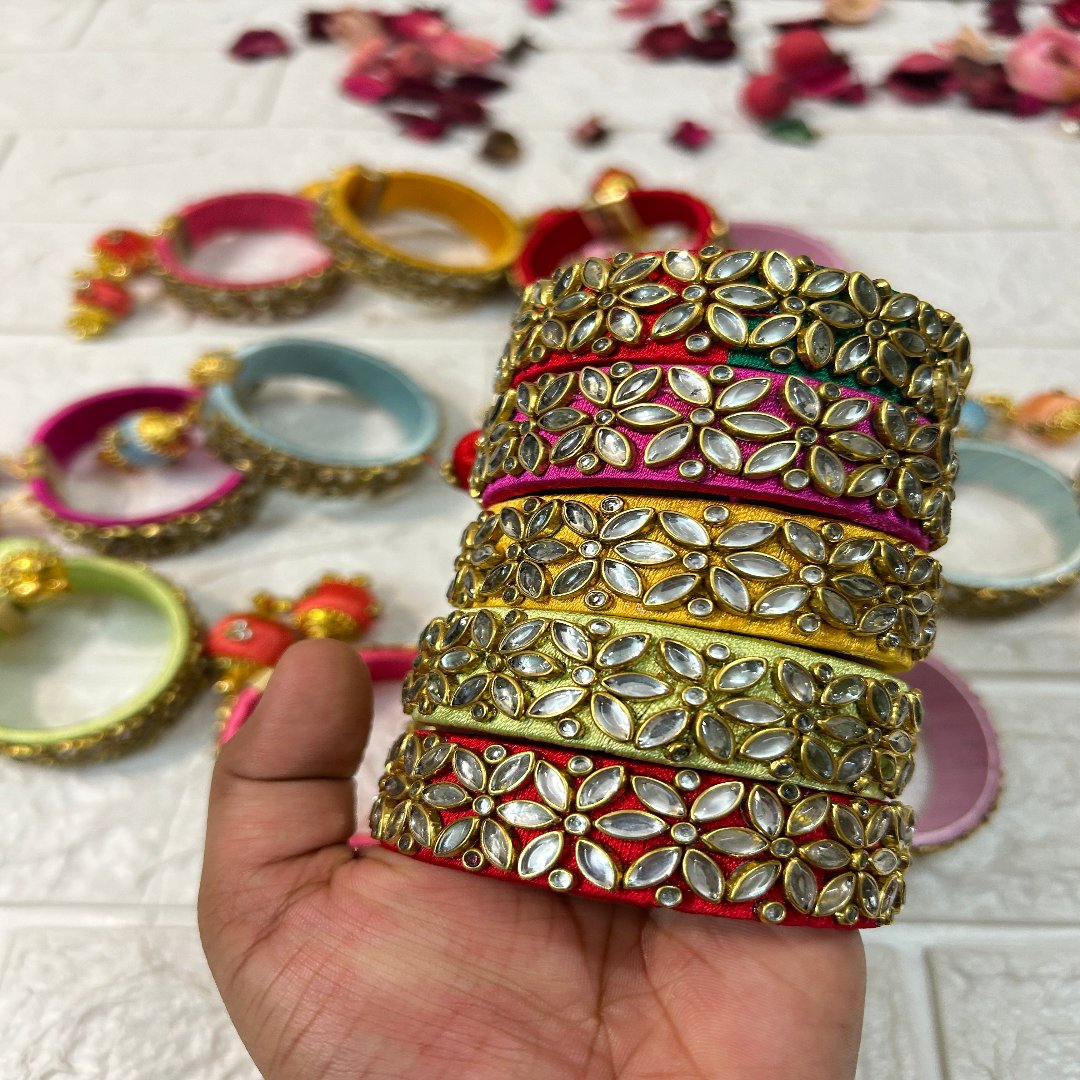 DesiTohfa Silk Thread openable Bangles with intricate gold and gem floral design held in hand