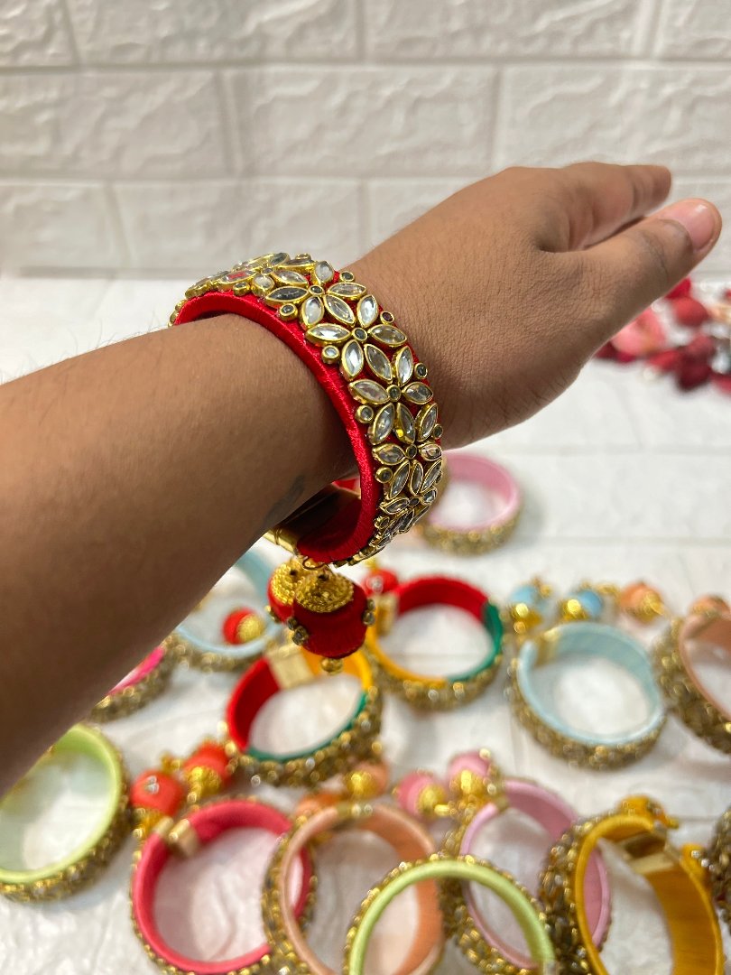 DesiTohfa Silk Thread openable Bangles in red with intricate gold and white floral design on wrist