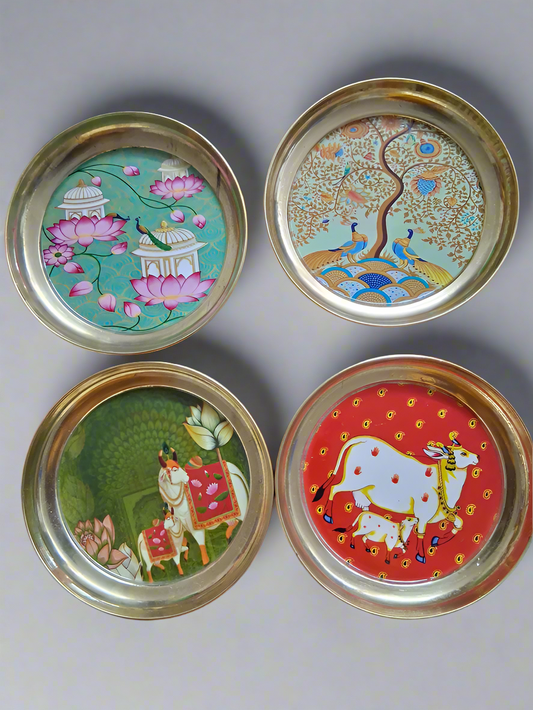Four decorative plates with colorful designs on a dark background