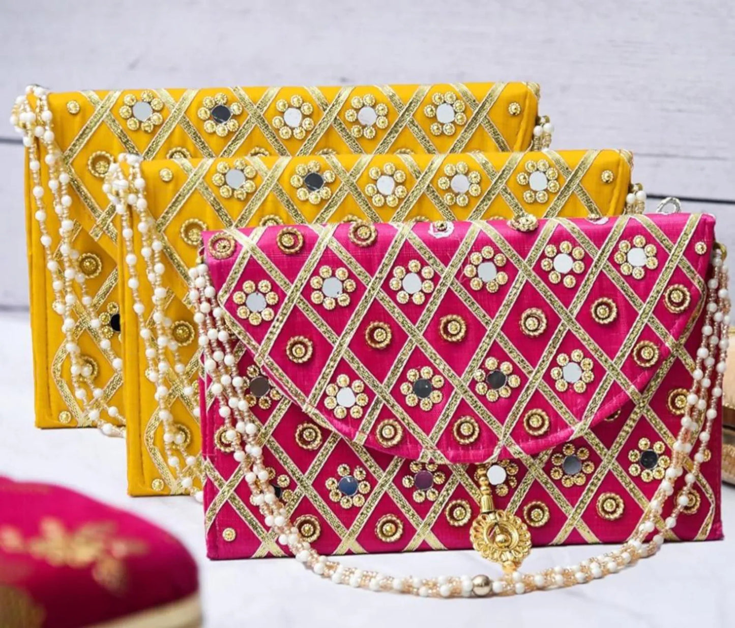 Add a vibrant ethnic touch to your celebrations with this Mirror Work Clutch, perfect for Mehendi & Sangeet return gifts. Stylish, handcrafted, and ideal for weddings, bridesmaid favors, and festive gifting.