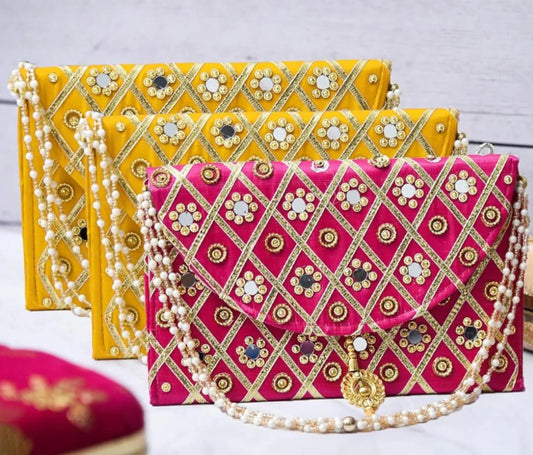Add a vibrant ethnic touch to your celebrations with this Mirror Work Clutch, perfect for Mehendi & Sangeet return gifts. Stylish, handcrafted, and ideal for weddings, bridesmaid favors, and festive gifting.