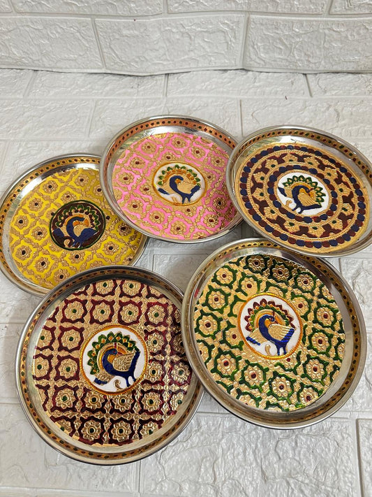 Set of decorative plates with peacock designs on a tiled floor.
