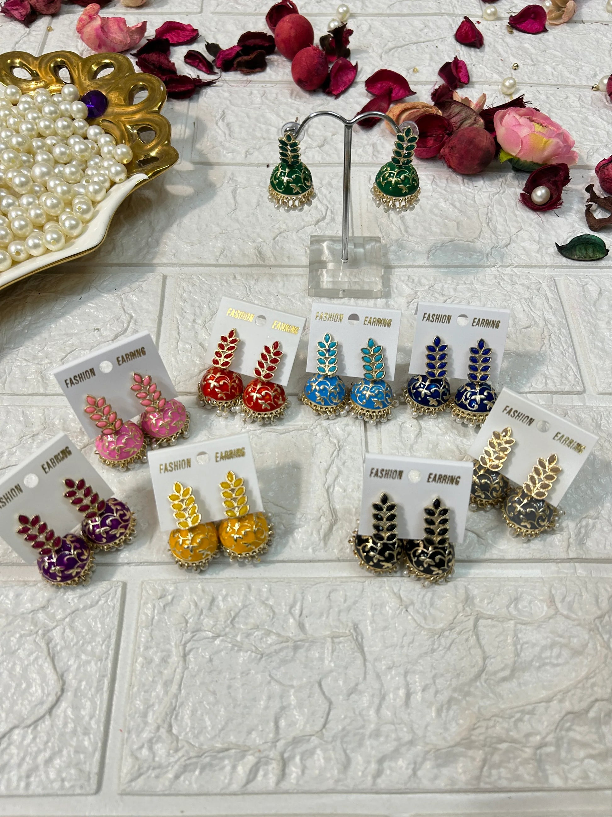 Colorful collection of DesiTohfa Jhumki Earrings with intricate designs displayed on white surface