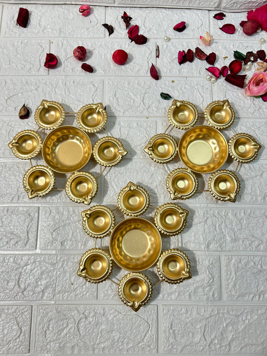 Set of three golden Metal Urli candle holders with decorative bowls and intricate edges by DesiTohfa