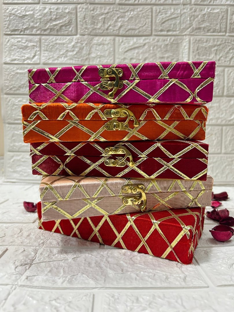 Stack of colorful DesiTohfa Shagun Boxes with golden lattice patterns and secure clasps