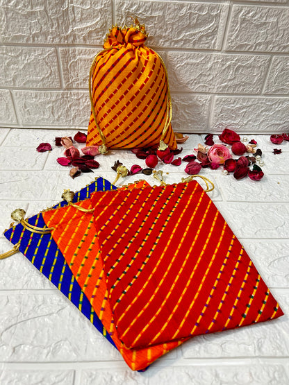DesiTohfa multicolor Leheriya gift bags in orange, red, and blue with gold drawstrings and decorative dried flowers