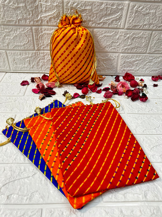 DesiTohfa multicolor Leheriya gift bags in orange, red, and blue with gold drawstrings and decorative dried flowers